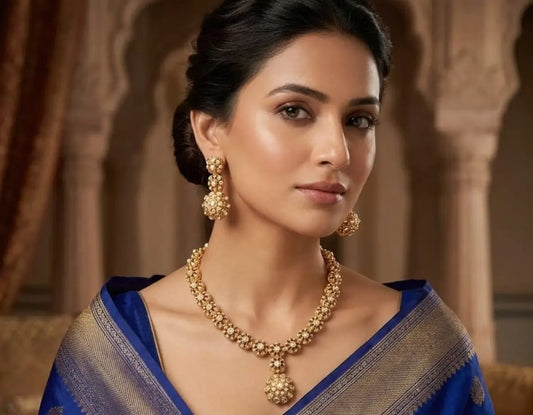 Woman wearing gold jewelry with a blue and gold traditional outfit.
