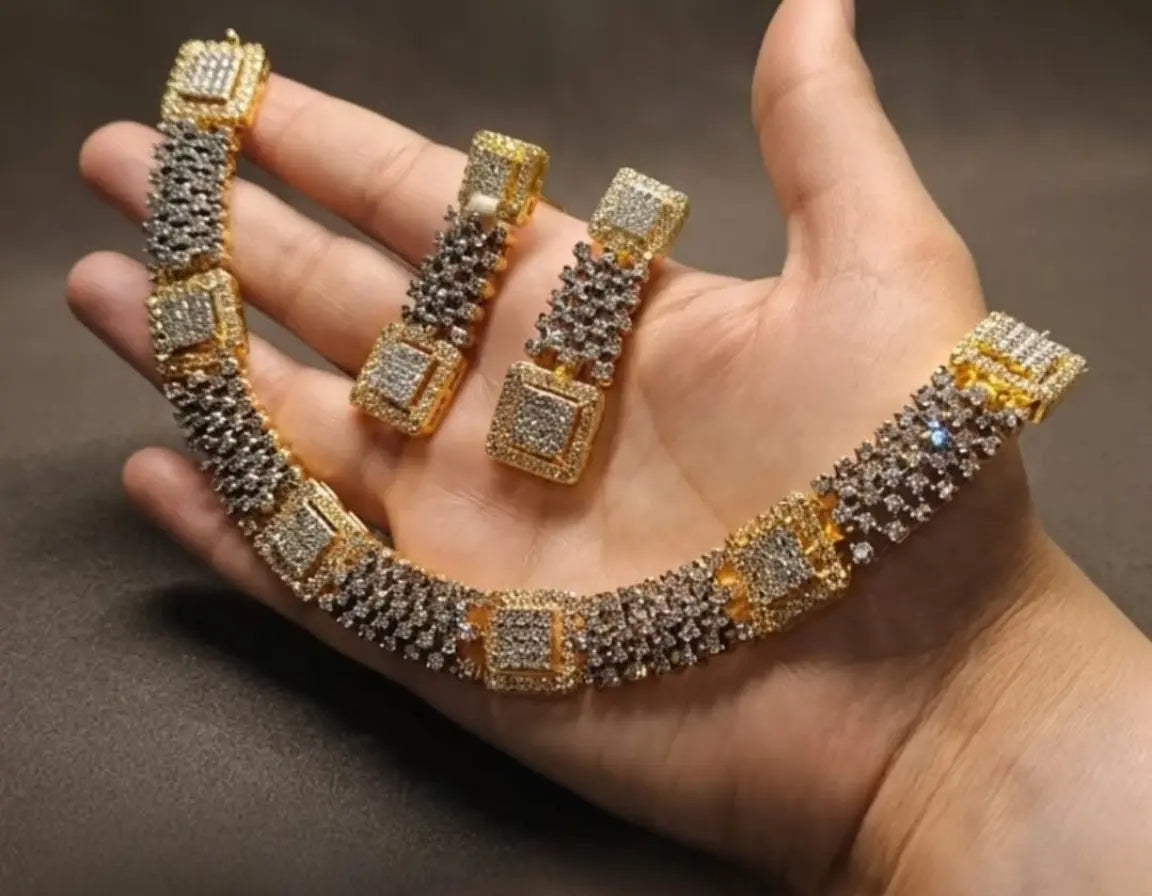 Gold and silver jewelry set on a hand against a dark background