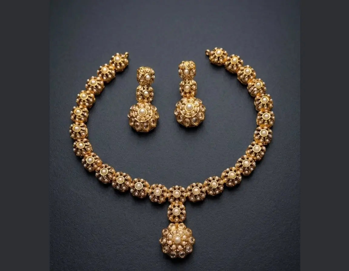 Gold necklace and earrings set on a dark background