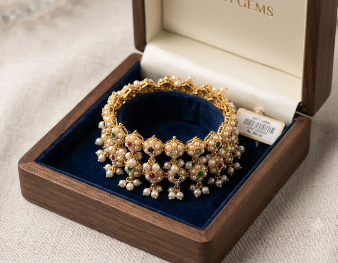 Gold bracelet with pearls and gemstones in a jewelry box